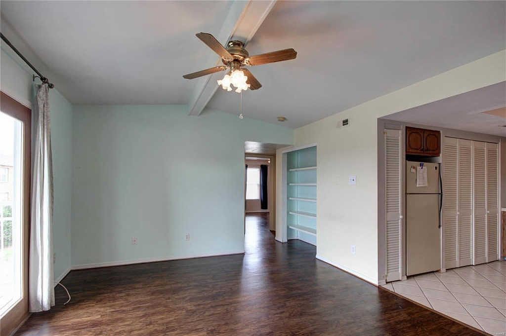 Living room with built-in bookcase, hallway and kitchen pantry closets