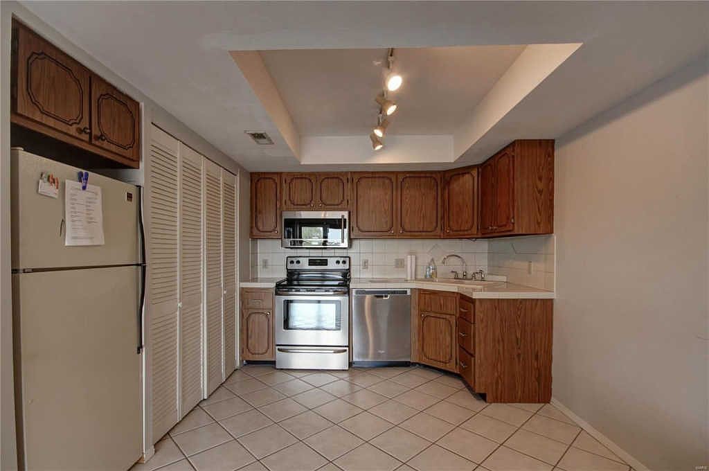 Kitchen with stainless steel range, microwave and dishwasher, oak cabinets and tile floor